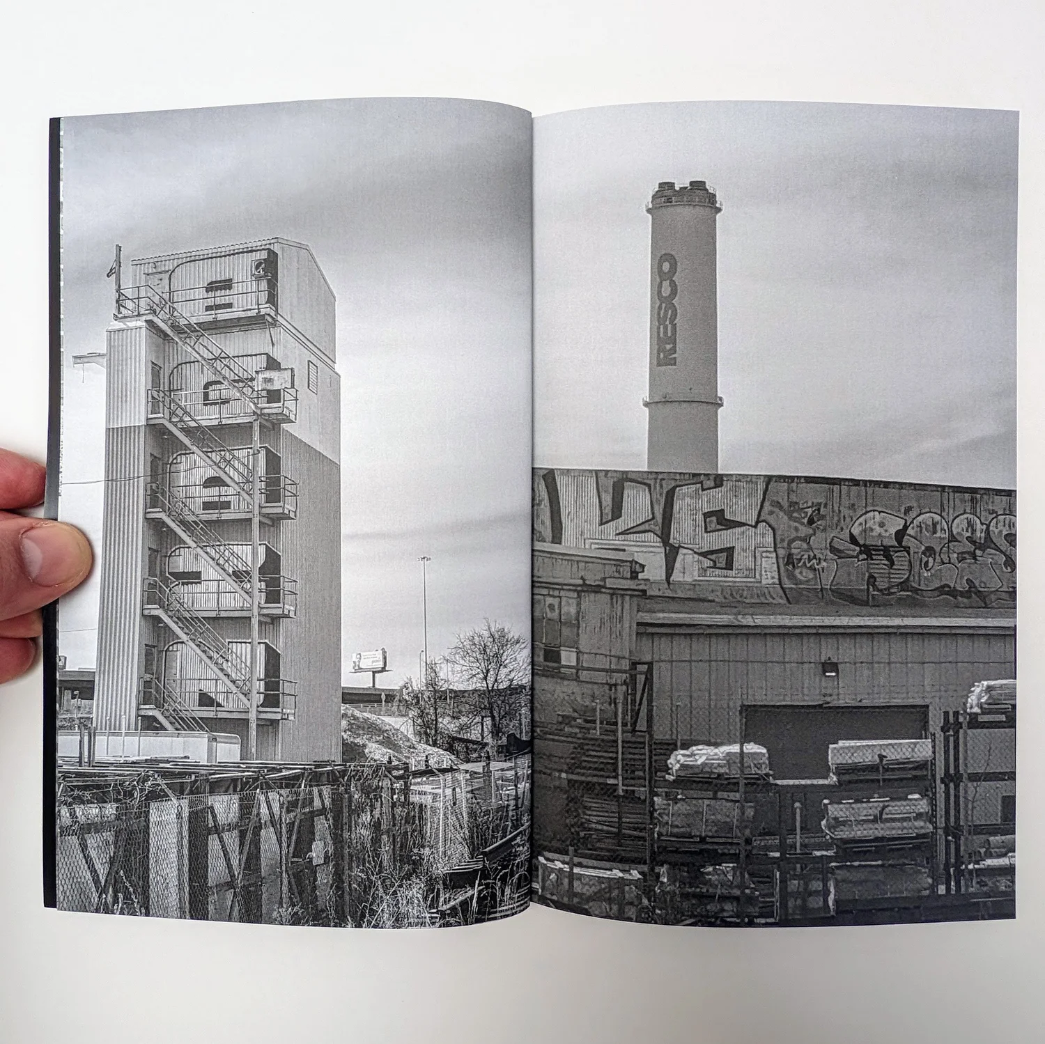 Zine spread: black and white photos of a smokestack and a graffiti-covered wall