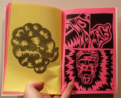 An open zine: black drawings on a yellow page and a pink page