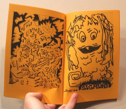 An open zine printed in black on orange paper